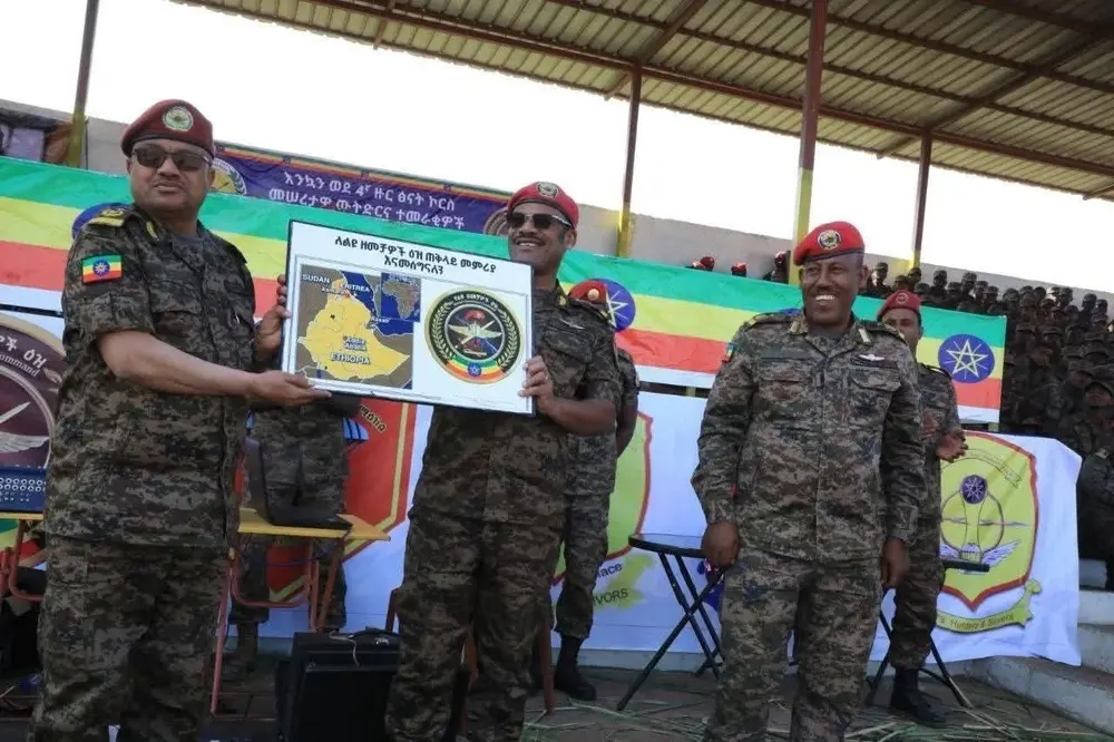 Three officers in Ethiopian army uniform hold a Special Operations Command plaque carrying a map of the Horn of Africa.